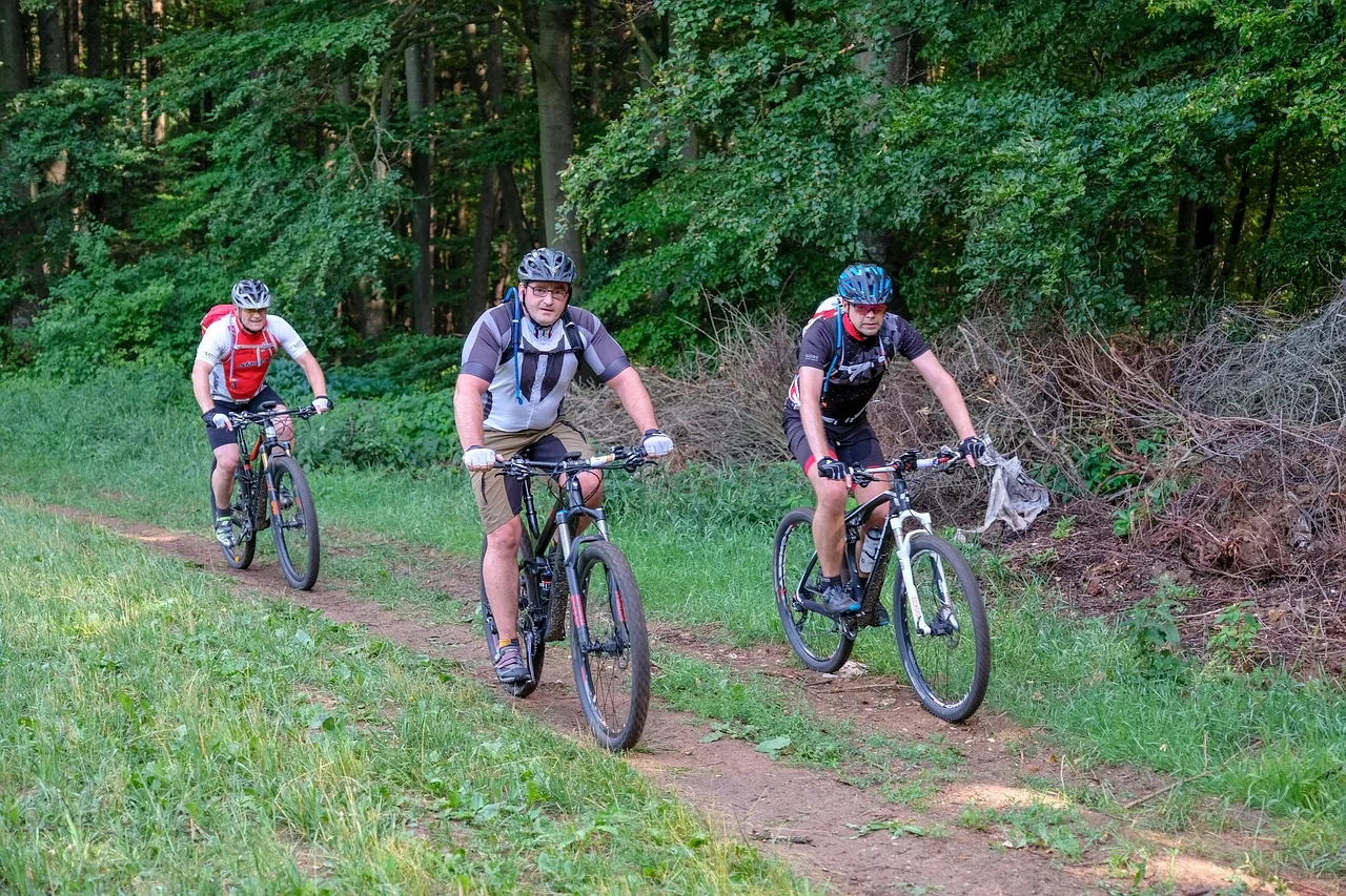 grupa kolarzy na rowerach XC na leśnej ścieżce - trening MTB